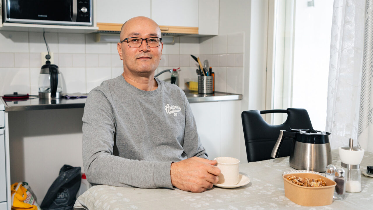 MIes istuu kahvipöydässä.