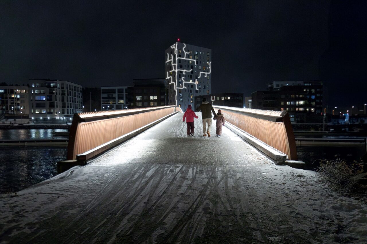 Mies ja kaksi lasta kävelevät ylisoutajan sillalla