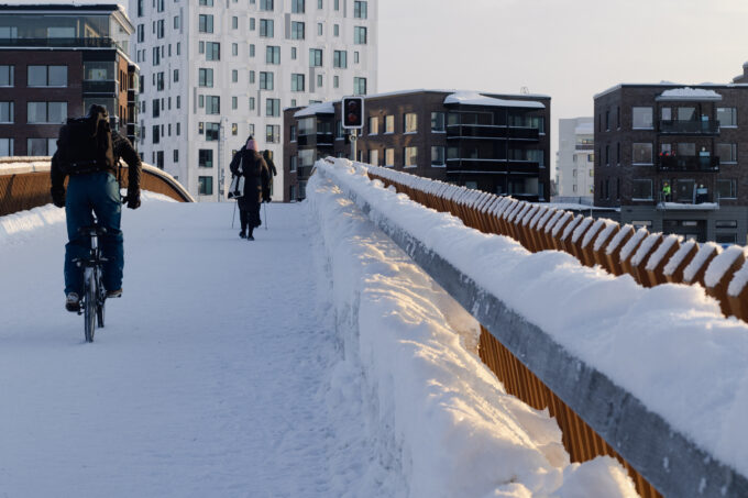 ihmisiä pyöräilemässä ja kävelemässä ylisoutajan sillalla talvella
