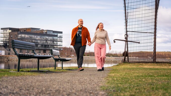 mies ja nainen kävelevät Joensuussa joen rannalla