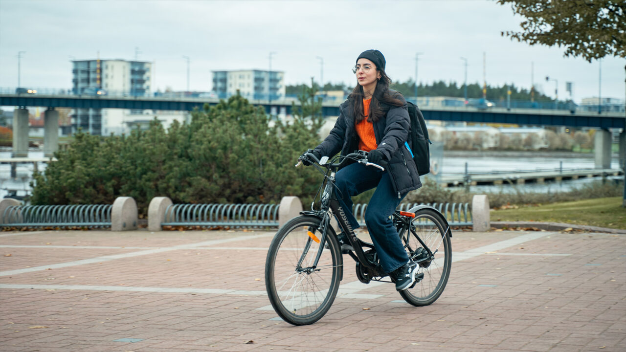 Nainen pyöräilee satamassa