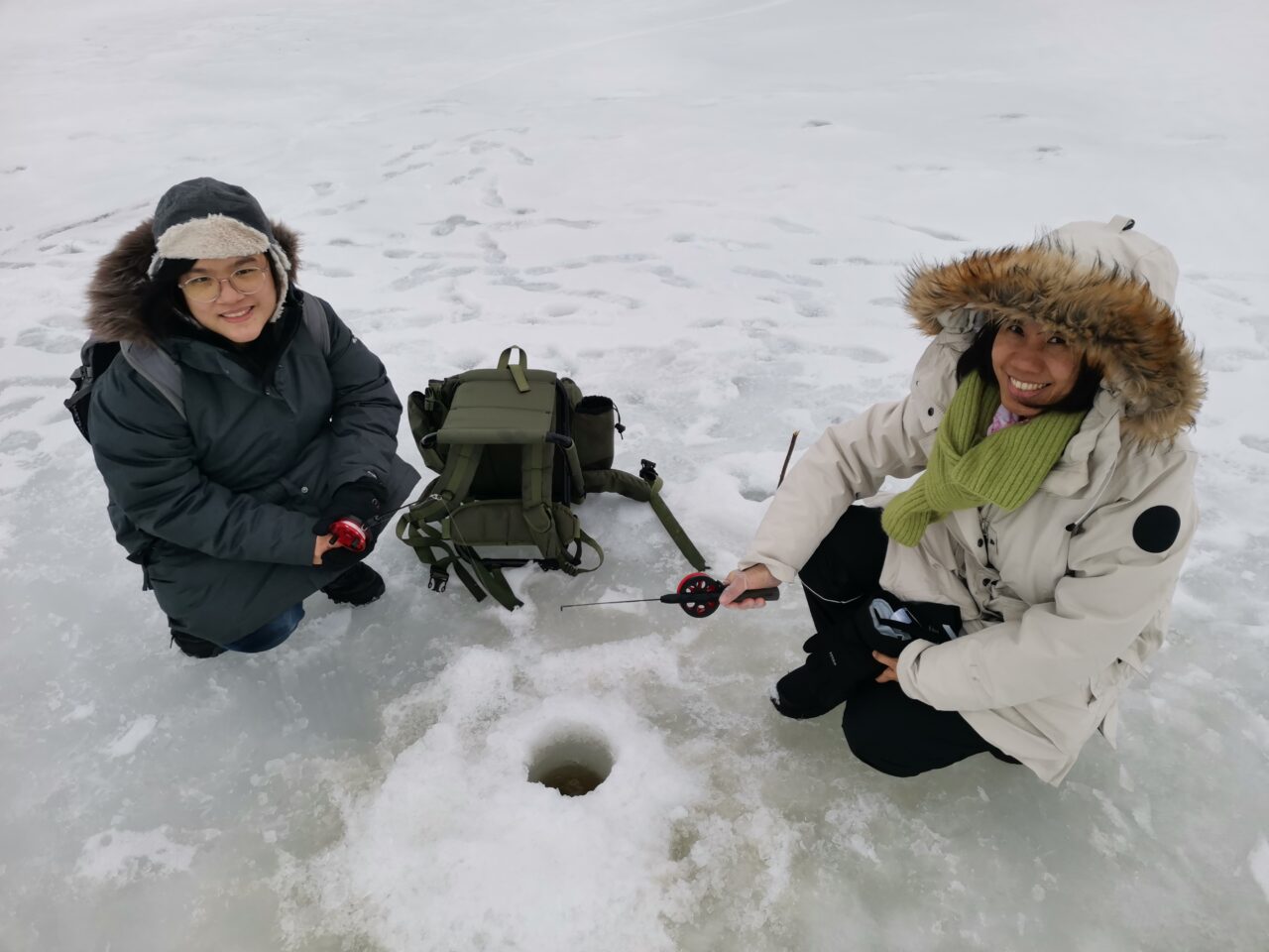 kaksi naista pilkillä järven jäällä